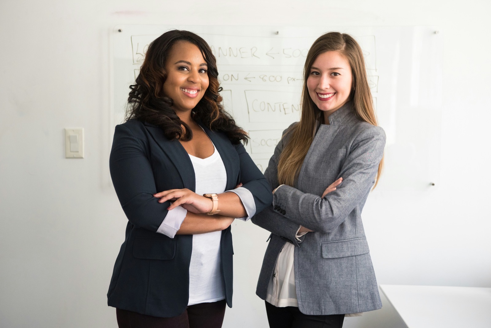 Deux collaboratrices souriantes dans les locaux de leur entreprise